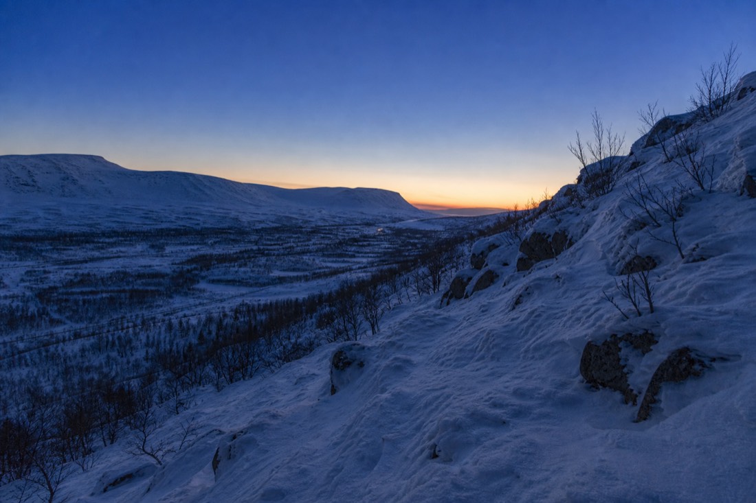Hora azul sobre un valle de Laponia, la nieve retiene la última luz