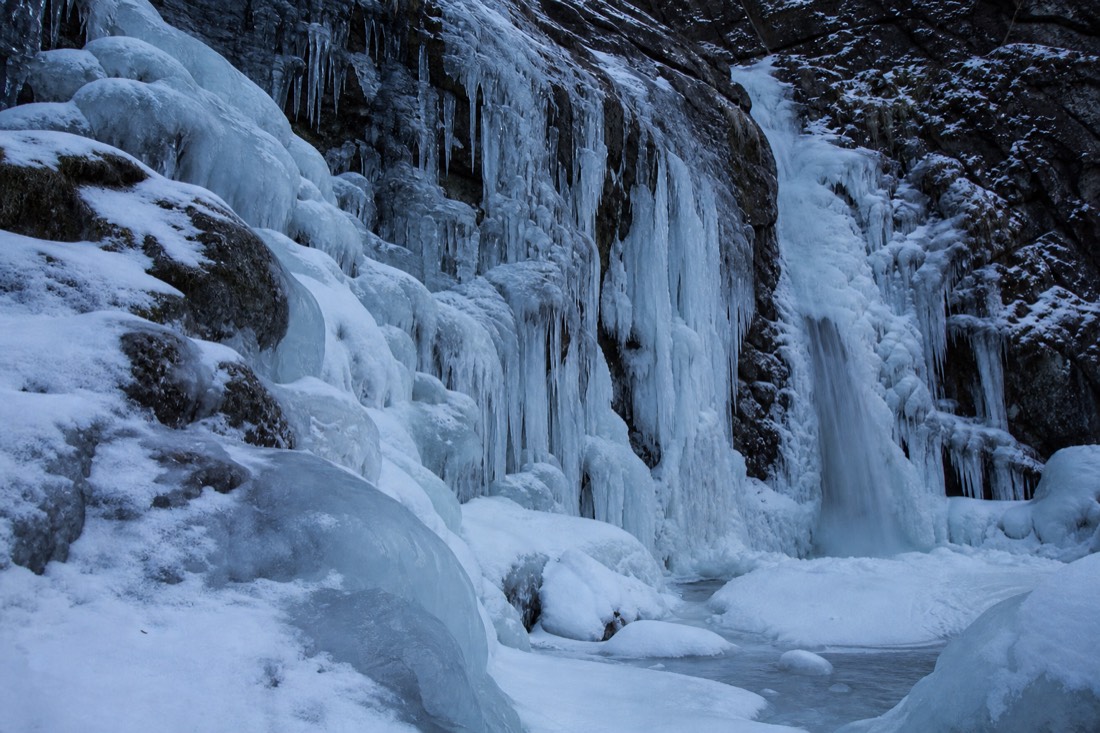A frozen waterfall and iced rock in a Lapland stream bed